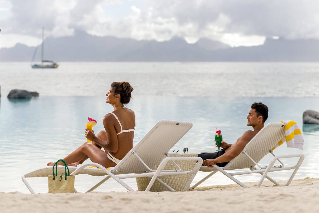| Blue Tahiti Travel Australian Couple Sunbathing on Lounge Chairs at the Intercontinental Tahiti Resort & Spa, Enjoying the Tropical Sun and Lagoon-side Relaxation.