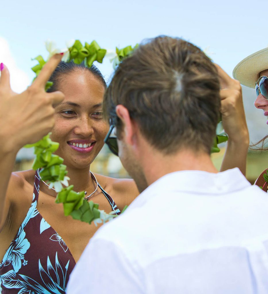 Tahitian Woman Warmly Greeting an Australian Visitor at the Airport, Showcasing the Hospitality Guided by a Tahiti Travel Specialist.