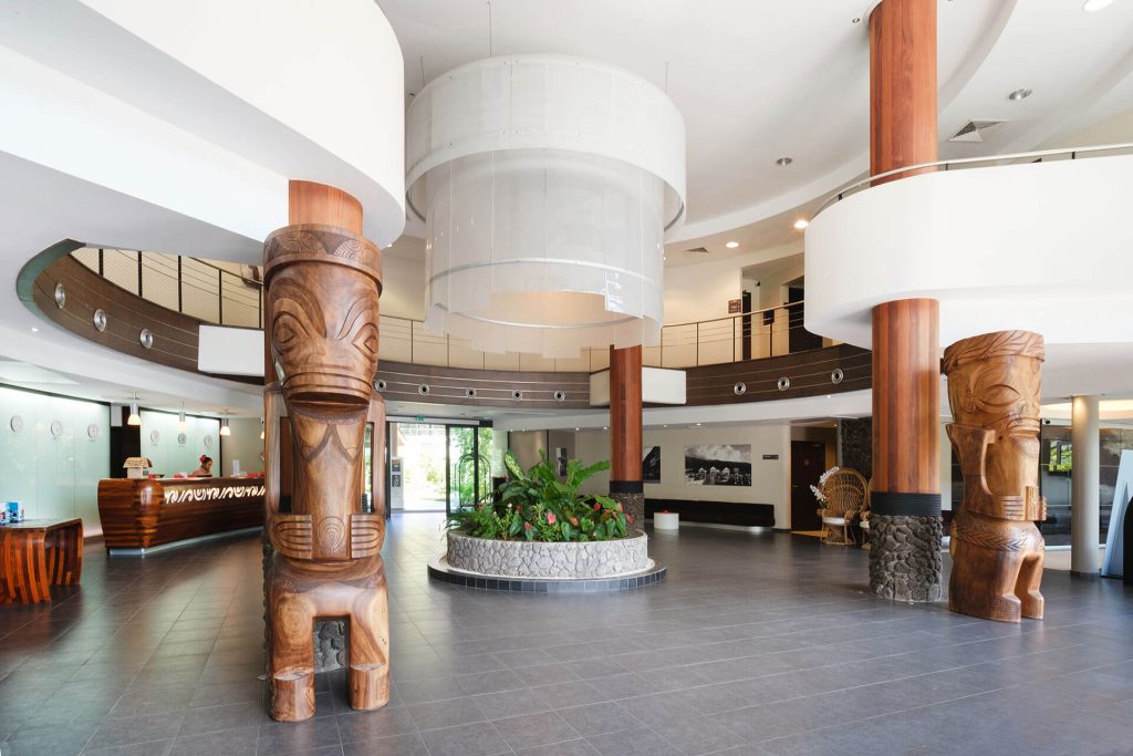 Elegant Lobby at Te Moana Tahiti Resort Featuring Polynesian-inspired Decor, Warm Lighting, and Inviting Seating Areas for Arriving Guests.